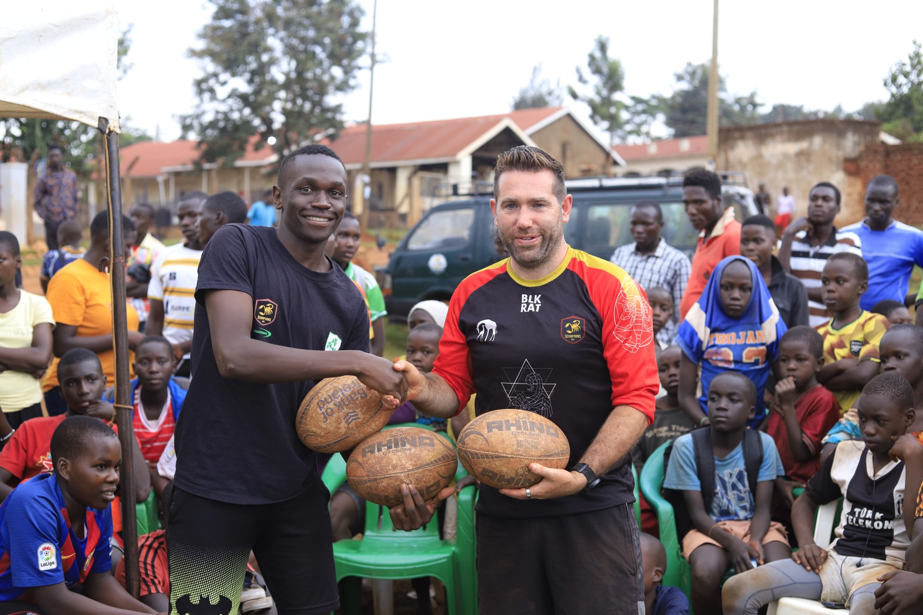 A coach from Ireland handing over equipment to a local Uganda club