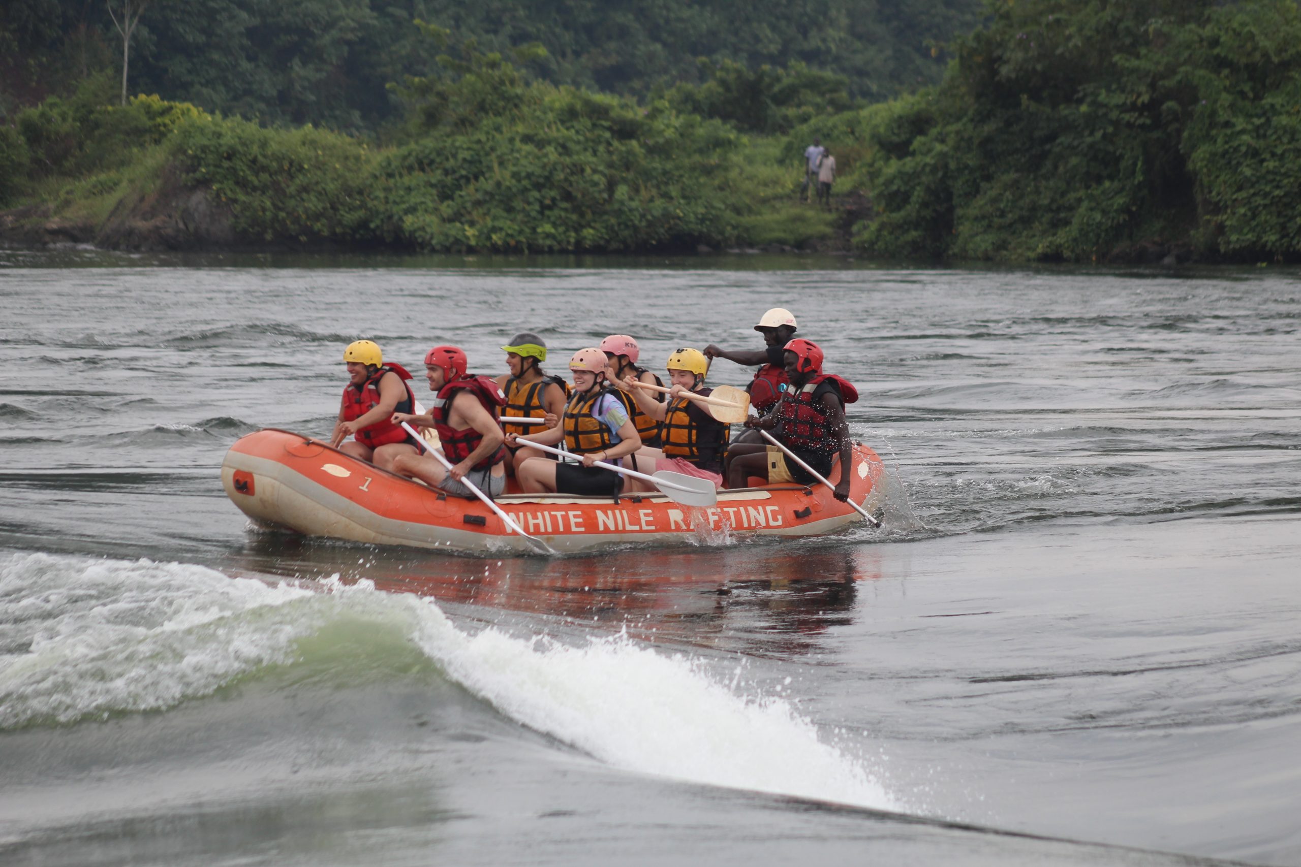 Group of adventure travelers rafting on the white Nile in Jinja as part their of their East Africa sports journey.